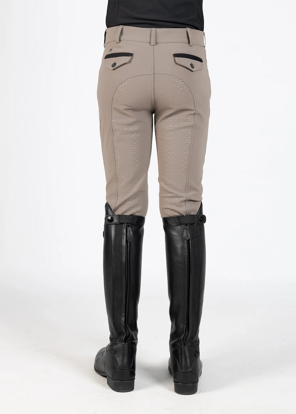 Beige riding pants with black knee patches and tall black boots on a white background